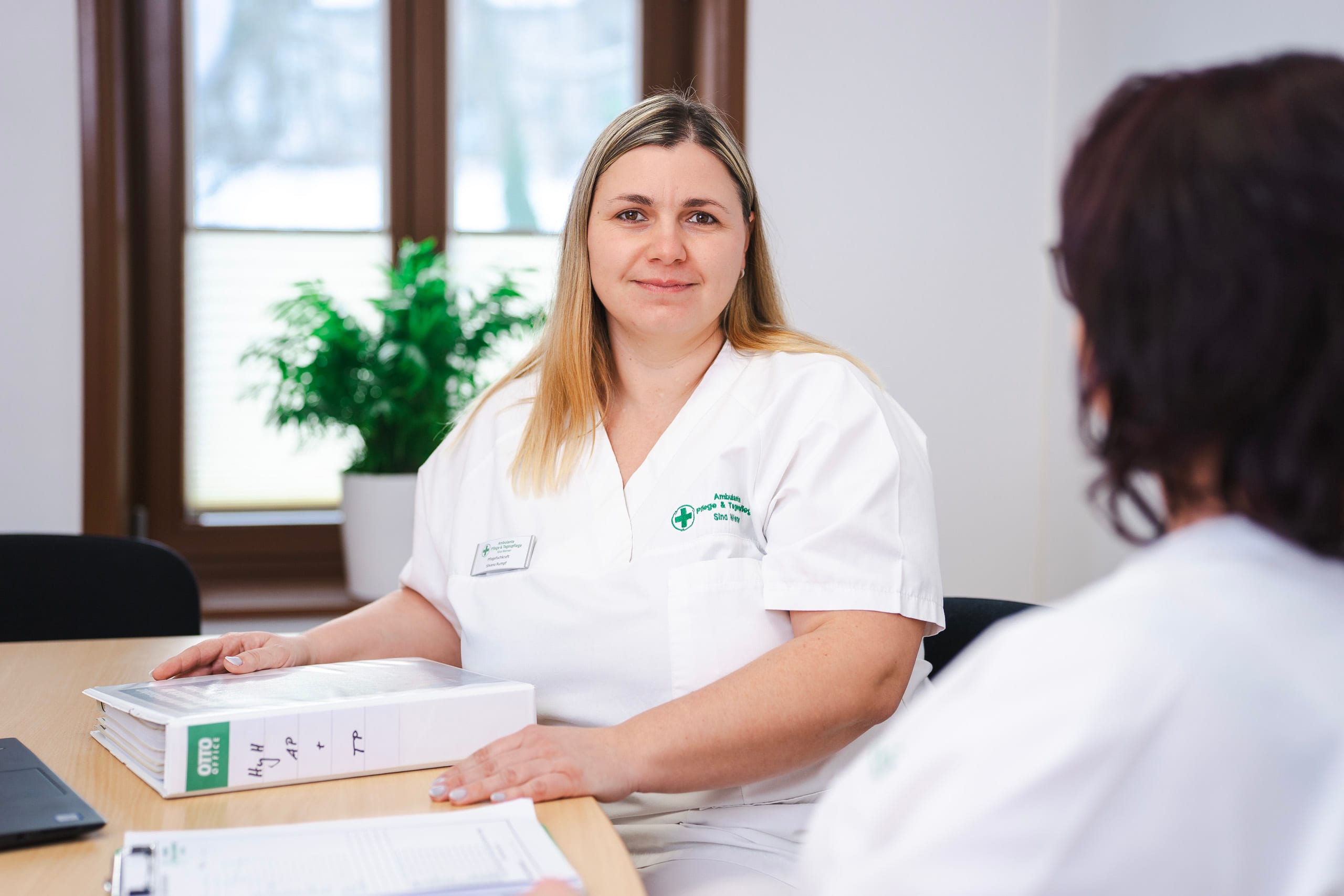 Pflegepersonal am Schreibtisch im Gespräch