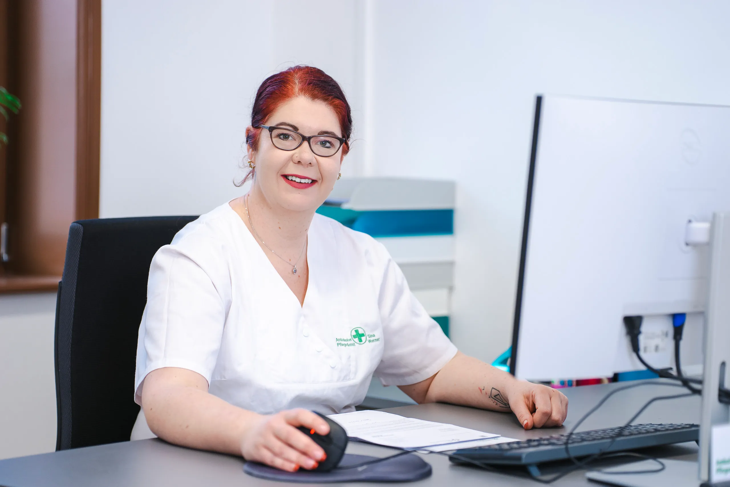 Frau im weißen Kittel am Computer