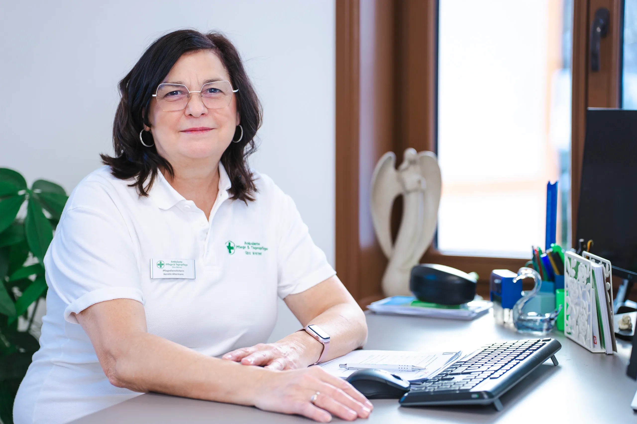 Frau im Büro am Schreibtisch mit Tastatur.