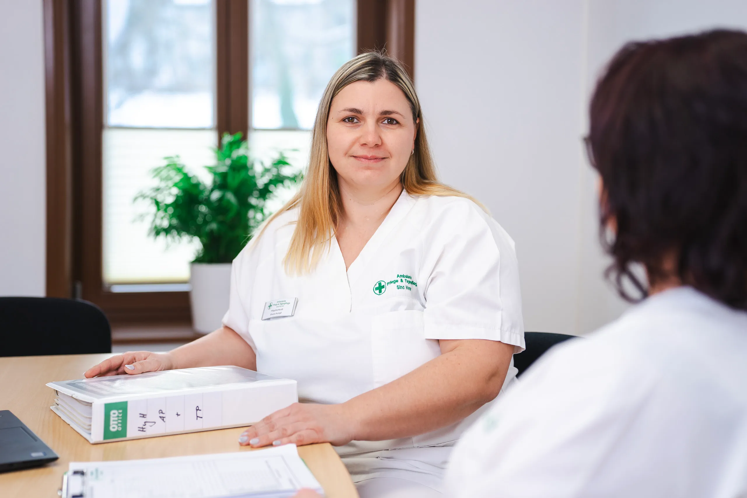 Pflegepersonal am Schreibtisch im Gespräch