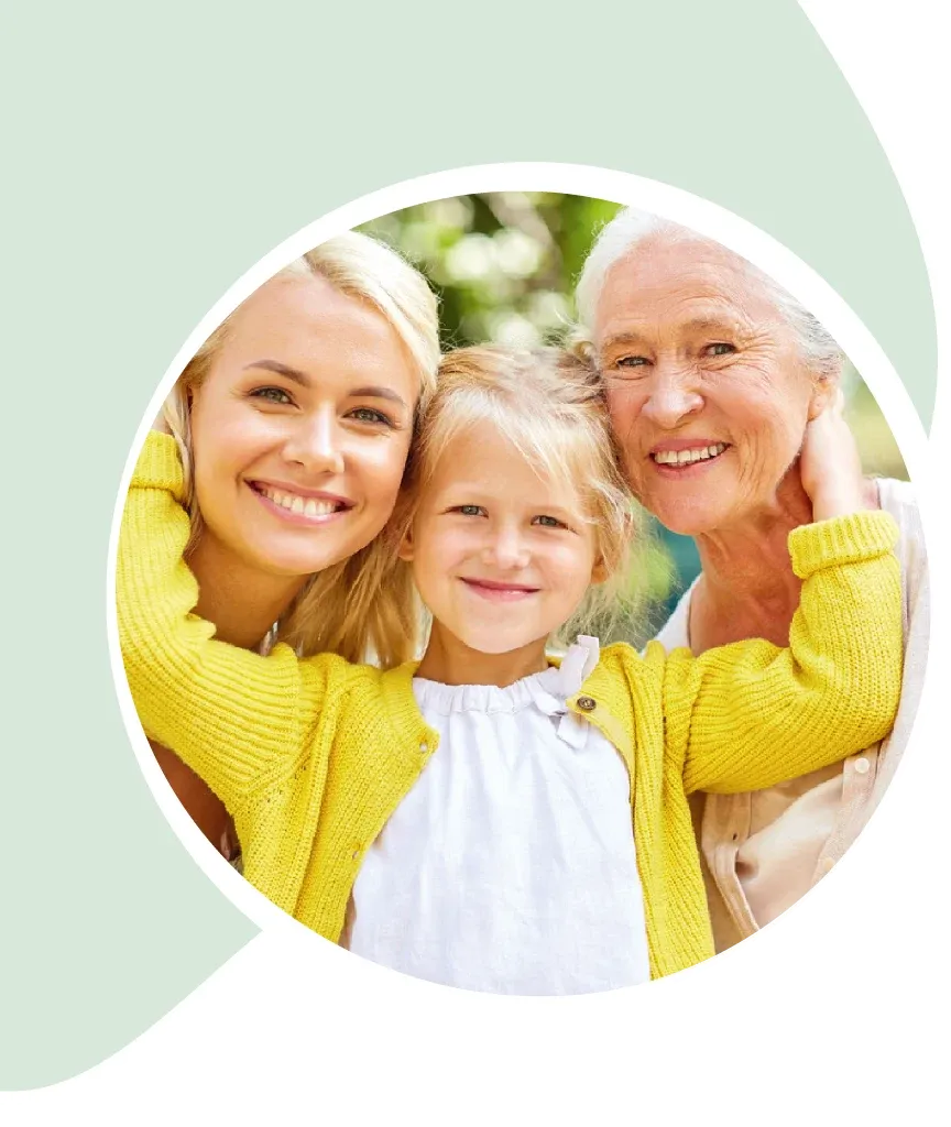 Drei Generationen lächeln glücklich zusammen im Garten.