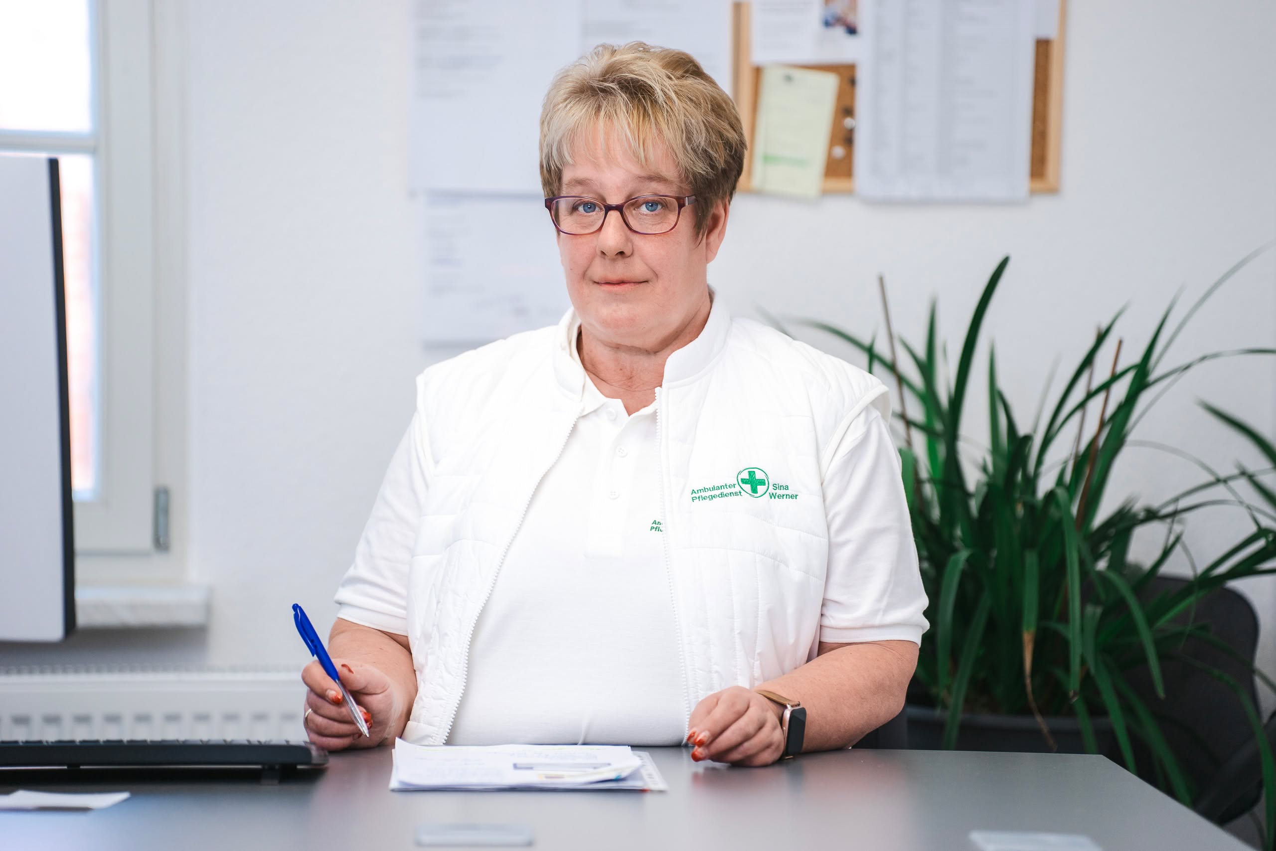 Lächelnde Frau arbeitend am Schreibtisch im Büro.